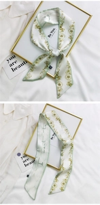 Detail of floral silk scarf with green trim and 'Be You' text on white background