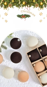 Détail de boules de Noël floquées de 6 cm dans une boîte cadeau avec branches de pin