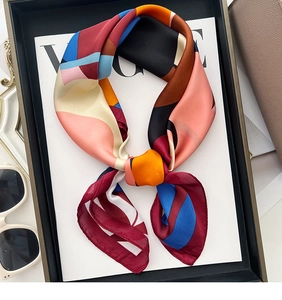 Detail of a silk scarf with abstract geometric patterns styled with fashion accessories