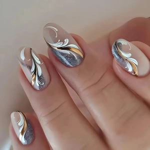 Vista macro di unghie finte ovali con base nude, linee bianche e glitter dorati brillanti