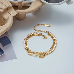 Detail of gold-plated stainless steel double-layer bracelet with safety pin and zircon