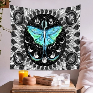 Detail of bohemian butterfly tapestry with moon phase and mandala art in a bedroom setting