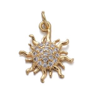 Macro view of a gold sun pendant with cubic zirconia and a top hanging ring