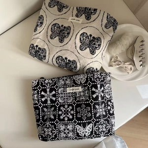 Detailed embroidery and butterfly patterns on canvas zipper pouches with Simple Wish tags