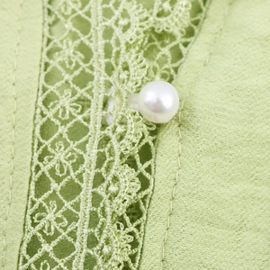 Light green blouse featuring elegant lace splicing and a pearl button detail
