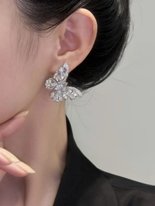 Close-up of model wearing silver butterfly earrings with sparkling cubic zirconia