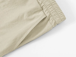 Close-up of the elastic waistband and side pocket stitching on khaki cargo shorts