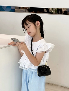 Mini-Umhängetasche für Mädchen im Retro-Stil kombiniert mit weißem Spitzenoberteil und Hose