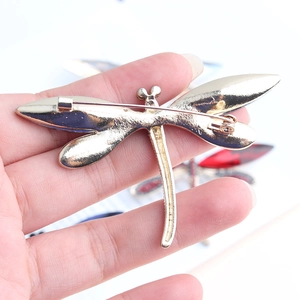 Detailed back view of gold dragonfly brooch with secure rotating pin safety clasp