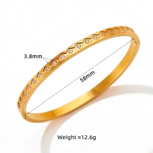 Gold stainless steel bangle with geometric diamond pattern and sparkling crystals