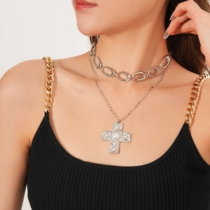 Close-up of double-layer cross pendant necklace with pearl detail on a female model