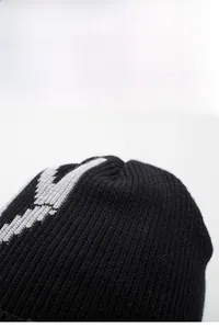 Nahaufnahme der schwarzen Strickmütze mit grauem geometrischem Muster und Textur