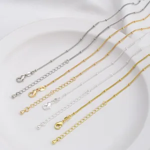 Close-up of gold and silver lobster clasps on beaded link chains with 925 stamps