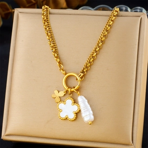 Detail of gold clover pendant with shell inlay and baroque pearl on thick chain link