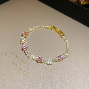 Detail view of pink square zircon stones on a champagne gold plated tennis bracelet