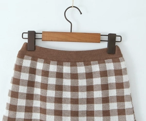 Detail of the high-waisted checkerboard knit shorts with brown and white patterns