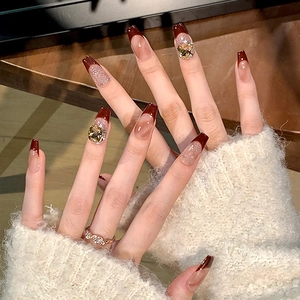 Classic French long trapezoid nails in brown cat eye effect with crystal rhinestones