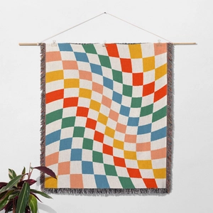 Close-up of Bohemian knit blanket with wavy checkerboard pattern and colorful fringes