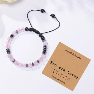 Handmade Morse code bracelet with natural pink crystal beads on a white minimal background
