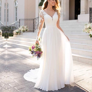 Detail of elegant white long sleeve bridal gown with delicate floral lace and deep V-neck