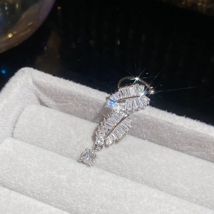 Macro view of silver feather ear cuff with sparkling cubic zirconia on grey velvet