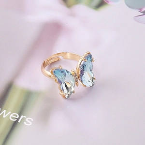Vista macro del anillo mariposa ajustable con alas azul claro y acabado dorado