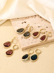 Macro détaillée de boucles d'oreilles en pierres multicolores avec placage or et zircons