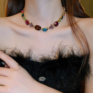 Close-up of vintage flower necklace with colorful crystals and pearl drop on model neck