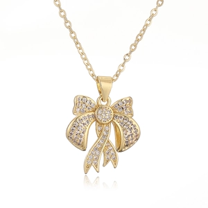Elegant gold bow pendant necklace with sparkling cubic zirconia on white background