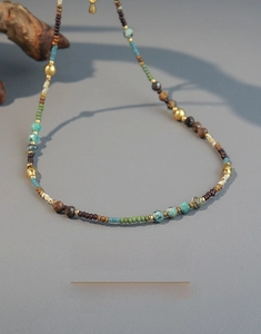 Flat lay of handmade bohemian necklace with turquoise stones and gold metal beads