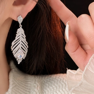 Vue macro d'une boucle d'oreille feuille avec placage argent et pierres de zircon