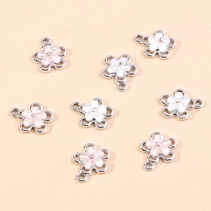 Flat lay of alloy enamel flower pendants with sparkling rhinestones in white and pink