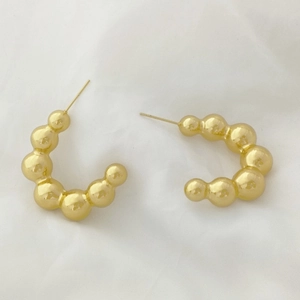 Detailed view of elegant gold-tone U-shaped earrings with round bead chain design