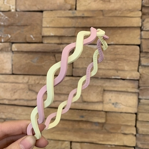 Detail of pink and beige matte twisted headband with non-slip inner teeth structure