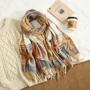 Close-up of soft plaid scarf with fringe tassels in brown, yellow and grey shades