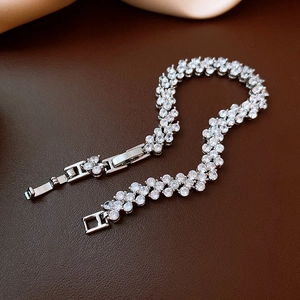 Detailed view of silver zircon bracelet with S-shaped pavé setting on leather background
