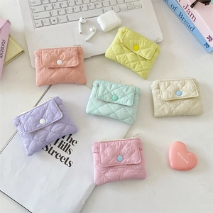 Quilted macaron coin purses in pastel colors displayed with laptop and tech accessories