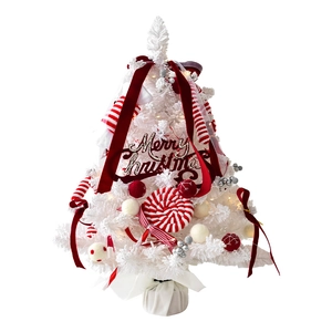 Mini white Christmas tree with red velvet ribbons and lollipop ornaments on white base
