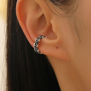 Close-up of retro silver skull ear cuff on model showing gothic punk style details