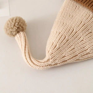 Close-up of ribbed knit texture on a warm winter baby hat with a contrast pom-pom detail