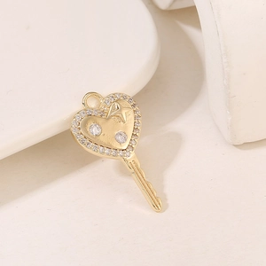 Detailed view of a gold heart-shaped key pendant featuring sparkling zircon star accents