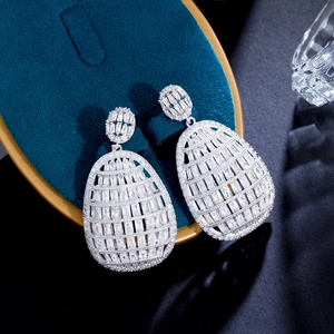 Macro shot of silver plated geometric drop earrings with sparkling pavé cubic zirconia
