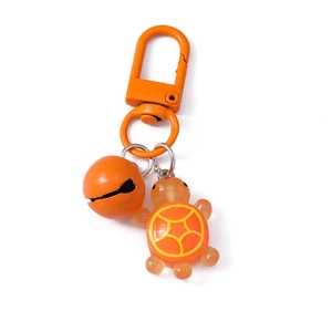 Cute orange resin turtle keychain with matching bell and metal hook on white background