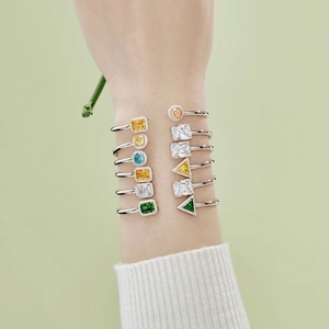 Macro detail of silver spring bracelet featuring colorful geometric cubic zirconia stones