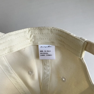 Detail view of cotton baseball cap interior showing stitching and 100% cotton label