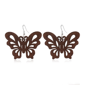 Detailed view of hollow butterfly-shaped wooden earrings with metal hooks on white background