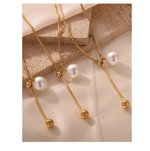 Detailansicht der goldenen Schlangenkette mit Hochglanzperle und Goldkugel-Anhänger