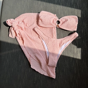 Pink three-piece textured bikini set with bandeau top and matching wrap skirt