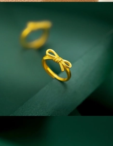 Detailed view of an 18K gold bow ring with delicate matte texture and adjustable band