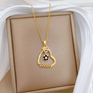Détail du pendentif cœur doré avec ballon de foot et cristaux sur de la soie
